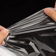 Person stretching some black pallet wrap between his hands