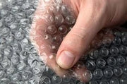 Hand pressing the bubbles of bubble wrap