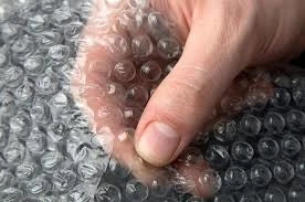 Hand pressing the bubbles of bubble wrap