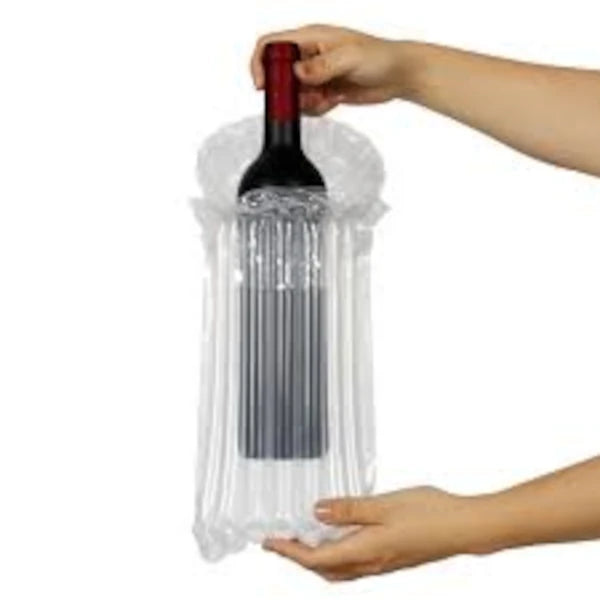 A hand holding bottle of wine while putting it into a protective Bubl air cushioning Pod for bottles