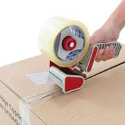closeup of a pre-loved cardboard box being sealed with clear sealing tape using a tape gun