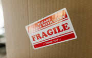 Fragile sticker on a cardboard box with a blurred background