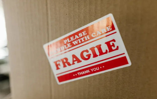 Fragile sticker on a cardboard box with a blurred background