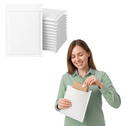 Woman holding a white mail lite padded envelope and removing a small box from the envelope  with a stack of envelopes above her on a white background