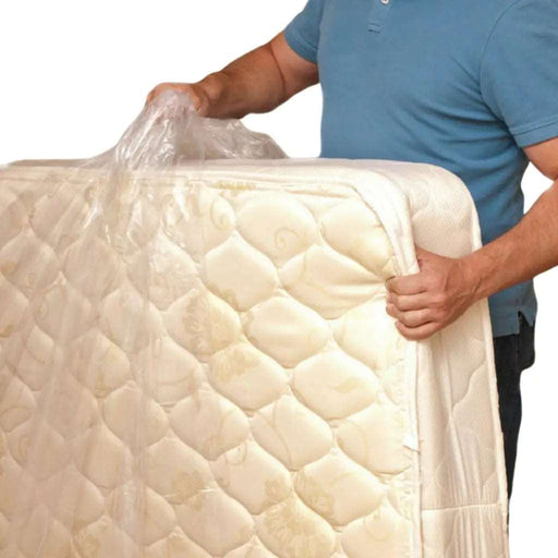 closeup of a man holding up a mattress and putting a mattress cover bag on it