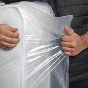 closeup of a man holding the plastic of a mattress bag cover