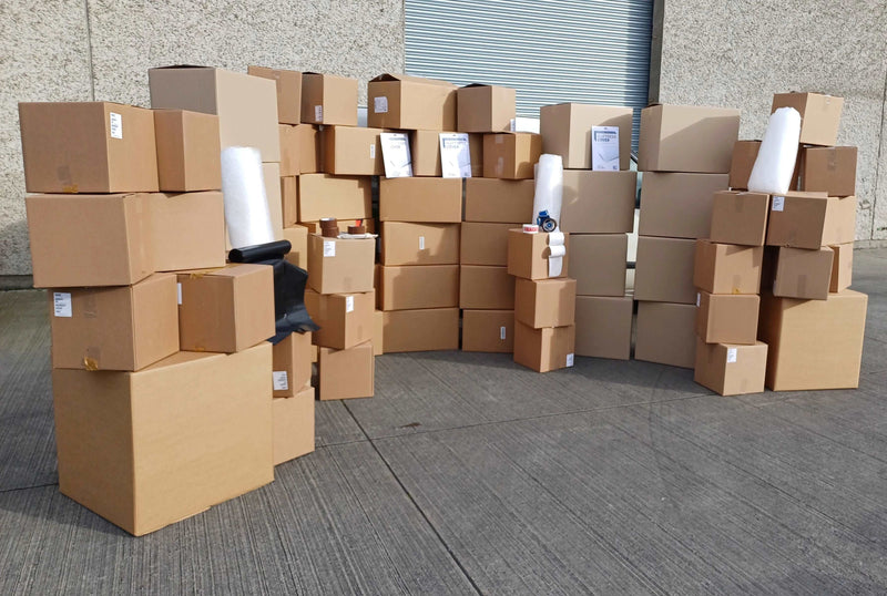 Mega Moving Kit with all boxes and accessories displayed in front of a warehouse roller shutter for perspective