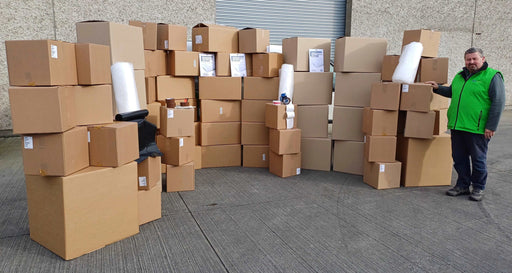Mega Moving Kit boxes and accessories displayed with a man standing beside them for perspective