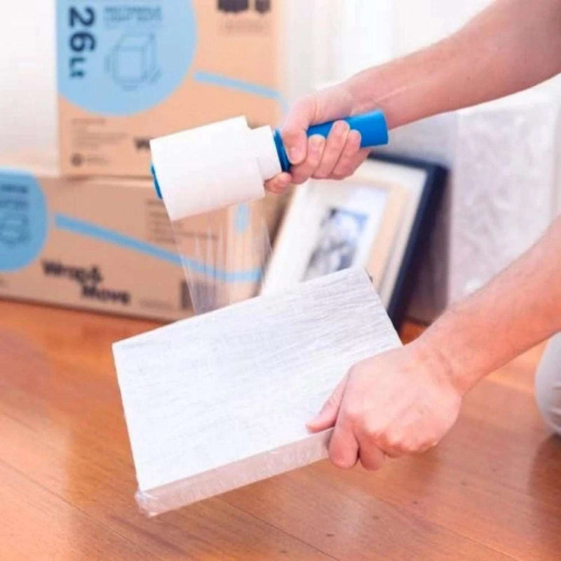 a man wrapping a cardboard box in mini pallet wrap in a living room