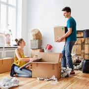 couple packing their belongings into cardboard boxes for moving house