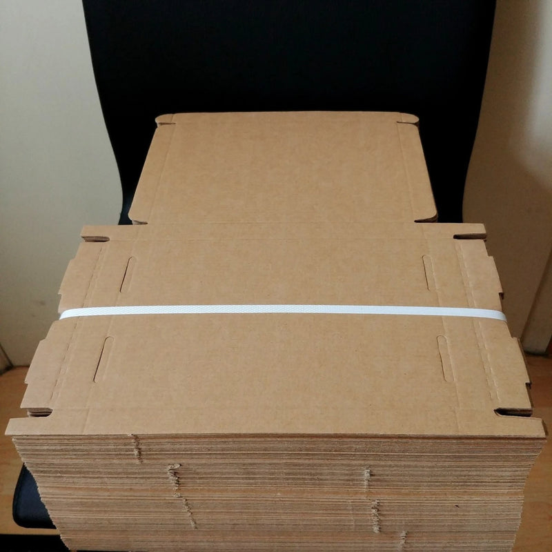 Stack of postal diecut cardboard boxes strapped together on a black chair.