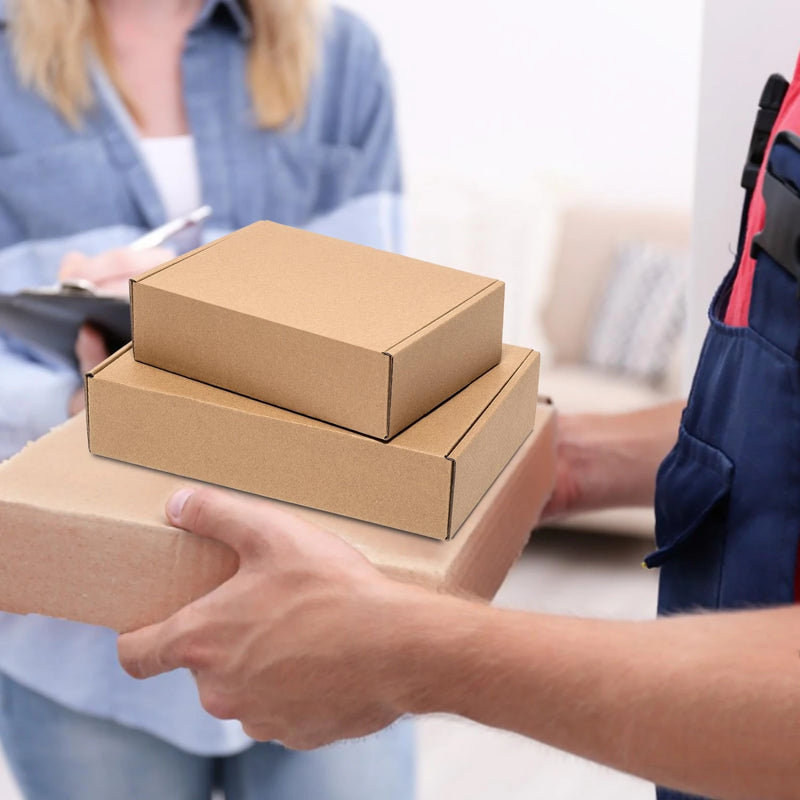 Person receiving a stack of postal cardboard boxes from a delivery person.