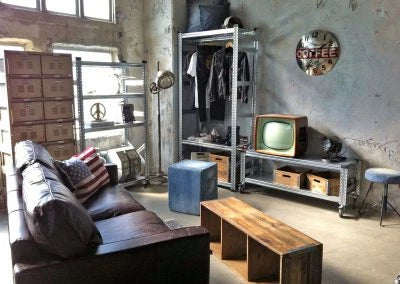 a living room with a television console table and shelving unit using a MetalSisteme 123 boltless shelving system