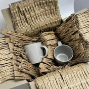 Two mugs inside a box lined with cardboard matting made with a CushionPack Cardboard Shredder