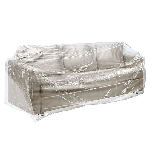 A transparent polythene furniture cover bag being used to cover a 3-seat sofa on a white background