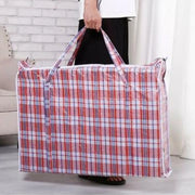 a man holding a red tartan plastic fabric large storage back in a living room environment