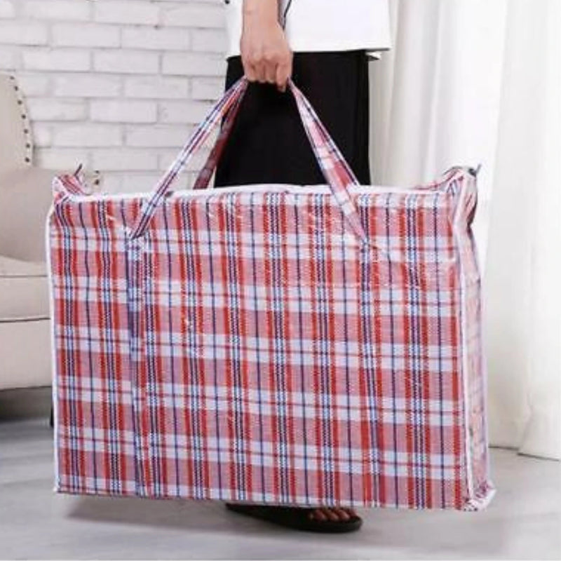 a man holding a red tartan plastic fabric large storage back in a living room environment