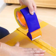 Person sealing a cardboard box using a tape dispenser and clear tape