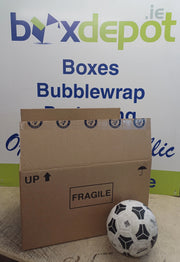 A large once-used preloved double walled cardboard box beside a football in front of Box Depot advertisement