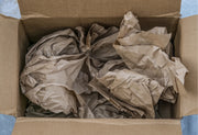 Cardboard box filled with crumpled brown paper voidfill.