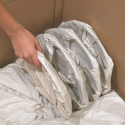 plates wrapped in white packing paper being stacked into a cardboard box
