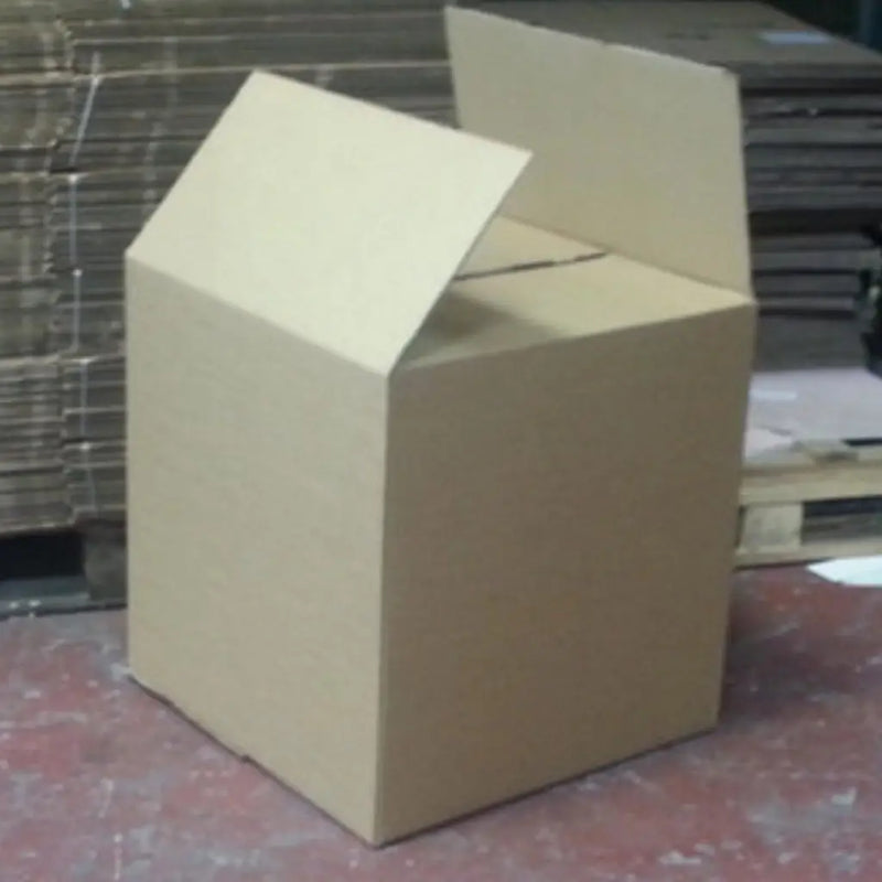 An XL double walled cardboard box on a red floor in front of a pallet of boxes to show how large the box is