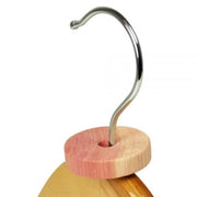 natural cedar wood moth repellent ring threaded onto a hangar on a white background