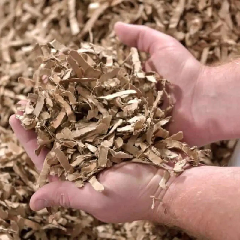 hands scooping up shredded cardboard that can used for packaging